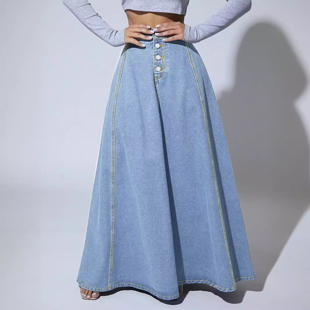 Long denim skirt worn by a person on a plain background
