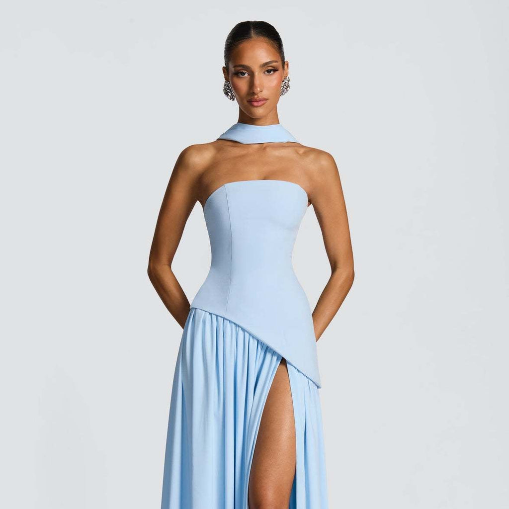 Woman wearing a light blue strapless gown with a slit on a white background