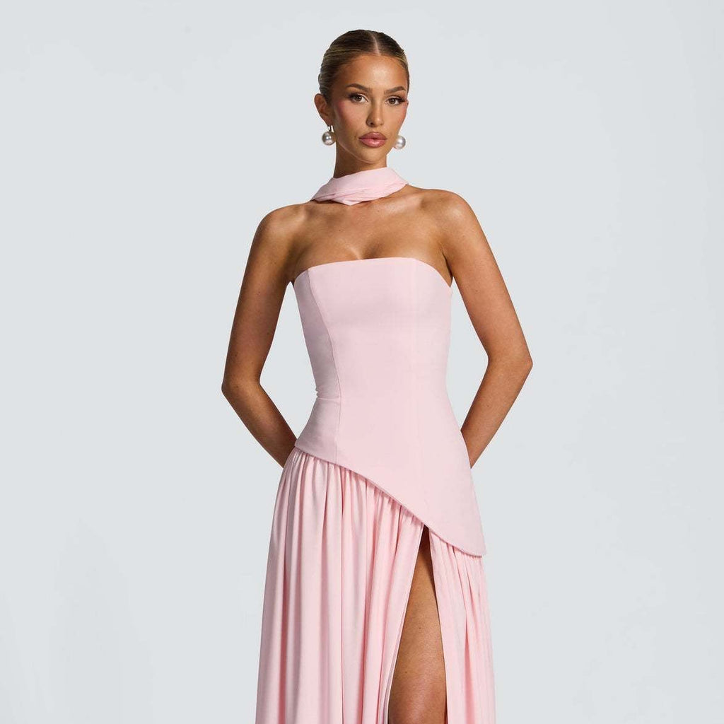 Pink strapless gown with a slit on a white background