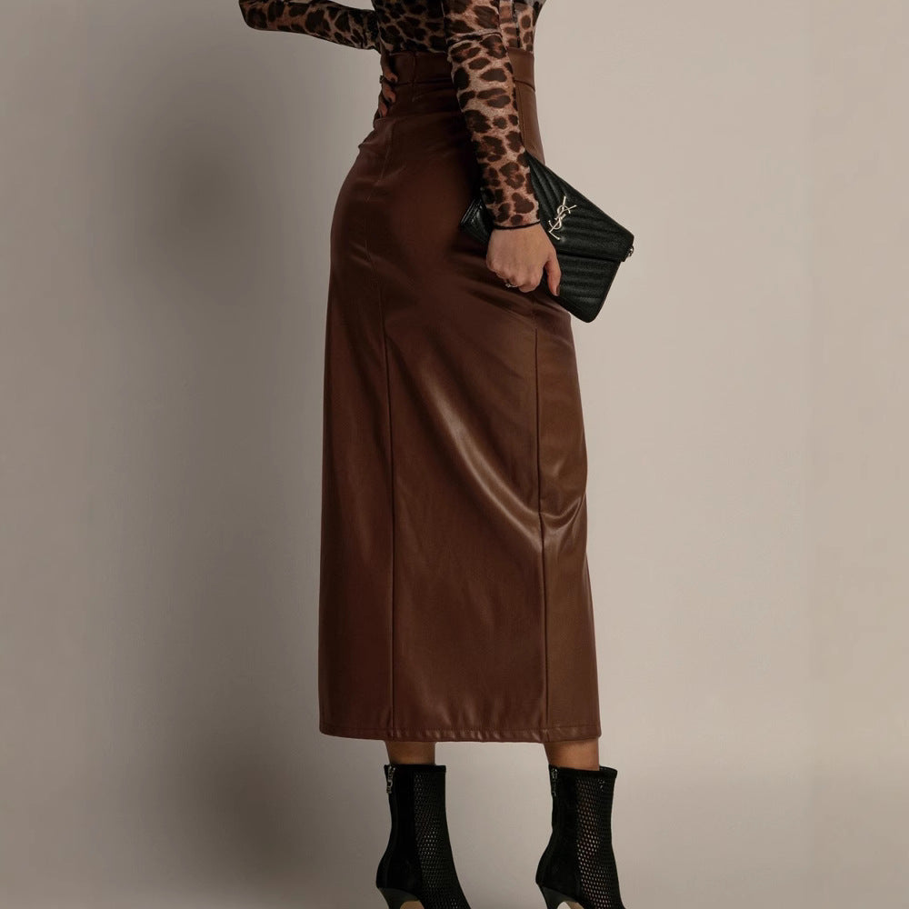 Person wearing a brown leather skirt and leopard print top against a plain background