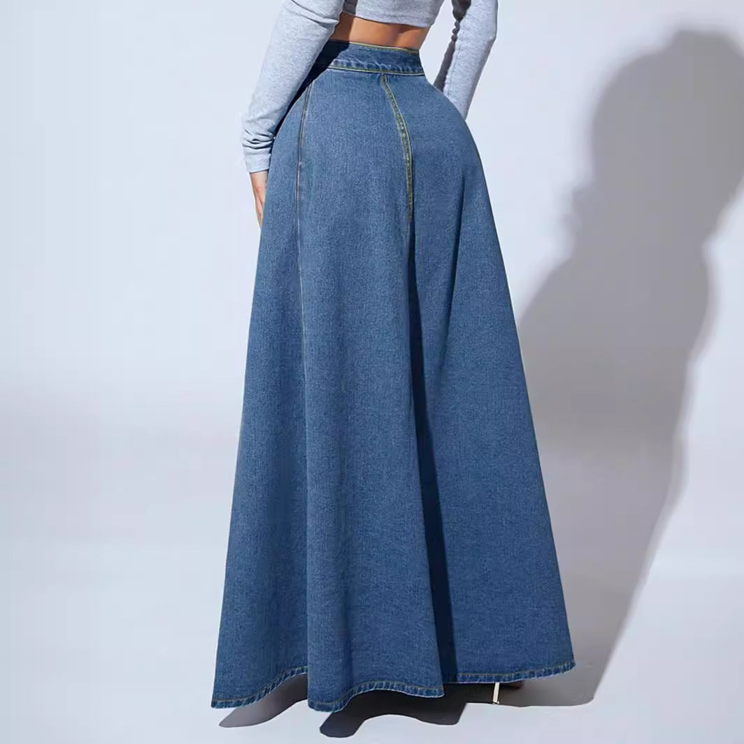 Long denim skirt worn by a person on a plain background